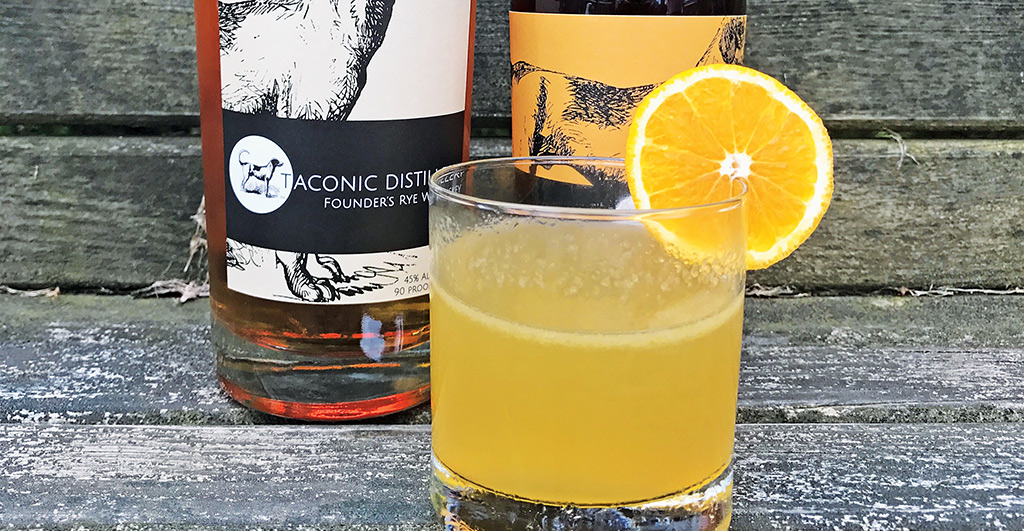 Taconic Sunrise cocktail with bottle of Taconic Distillery Rye Whiskey