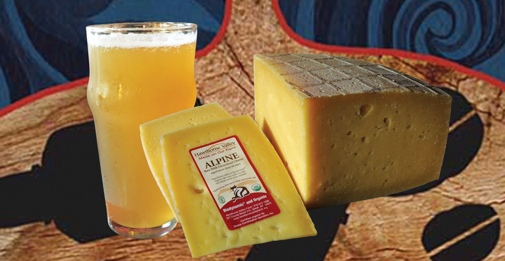 A glass of beer with two blocks of Hudson Valley cheese