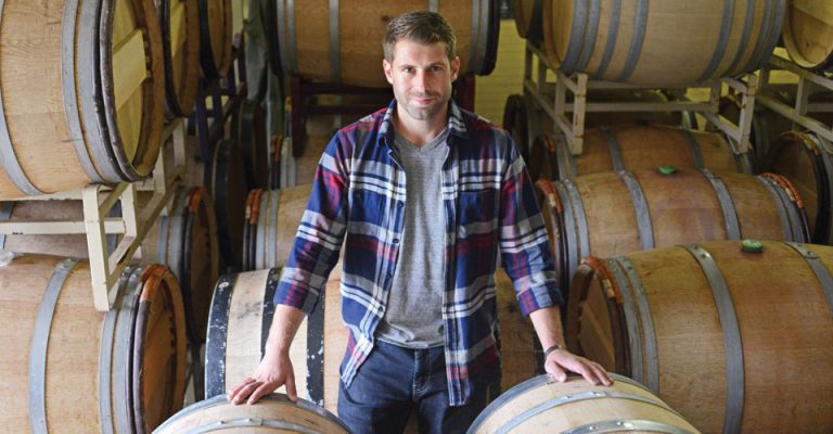view of Jonathan Lander, assistant winemaker at Robibero Family Vineyards, standing by barrels