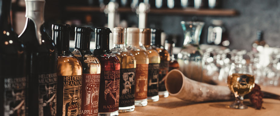 lineup of bottles of Helderberg mead ona bar with bone horn and glass