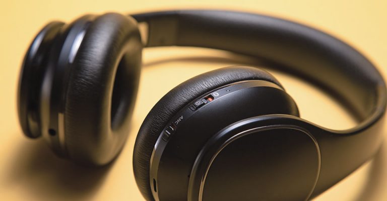 closeup of black headphones on a yellow background
