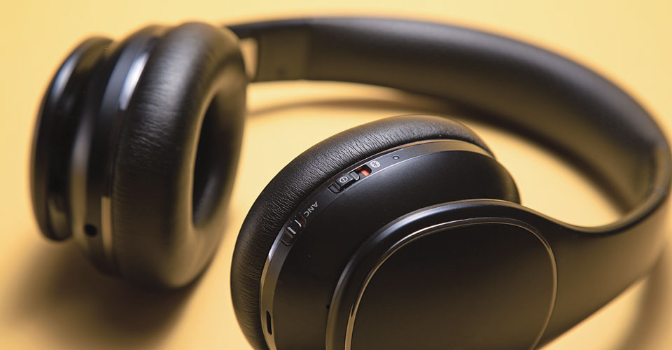 closeup of black headphones on a yellow background