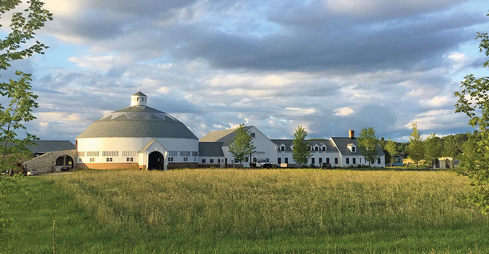 distant shot of round barn in grass field