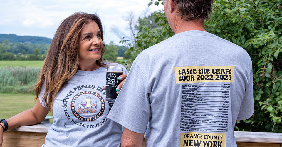 woman with beer in hand looking at man leaning on deck rail