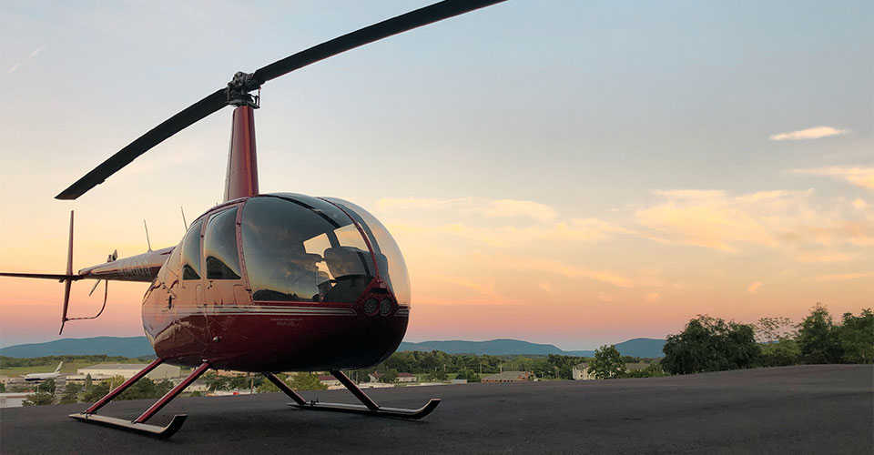 view of an Independant Helicopter with scenery and sunset in background.